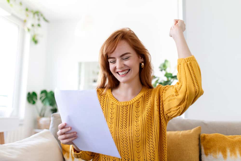 Excited young woman looking at the contract